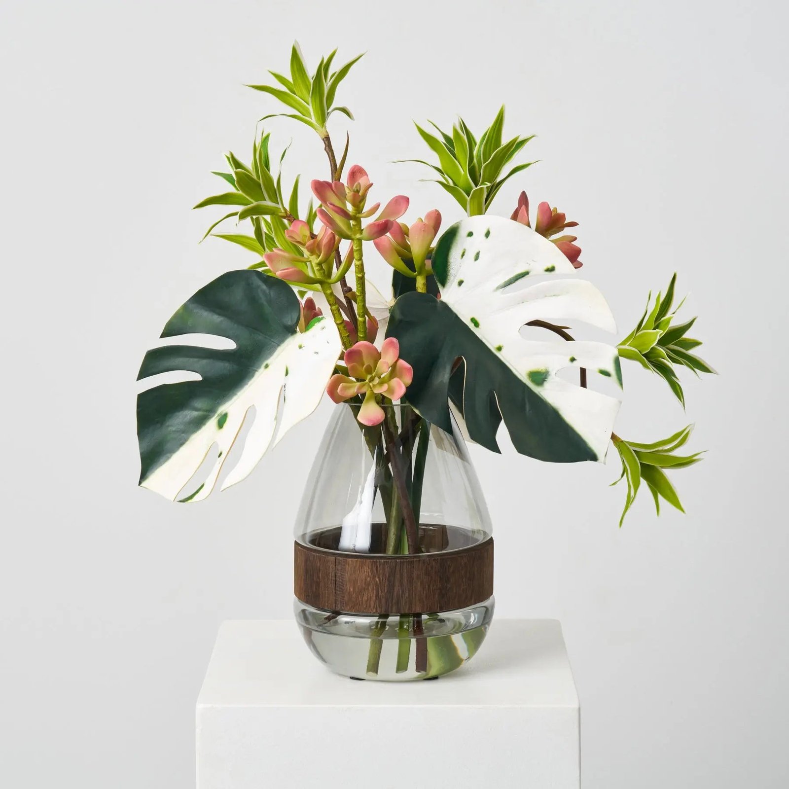 FAR1540TropicalMuse-GreenAlbinoMonsteraLeaf_Dracaena_SucculentinSmokeWoodVaseEverydayWaterIll_1 Tropical Muse - Green Albino Monstera Leaf, Dracaena & Succulent in Smoke Wood Vase Everyday Water Illusion Centerpiece Arrangement - Image 1